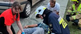 Na zdjęciu strażak Ochotniczej Straży Pożarnej wraz z ratownikiem medycznym podczas pokazu z udzielania pierwszej pomocy osobie poszkodowanej .