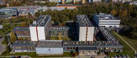Budynki UJ CM po termomodernizacji (OA: Budynki UJ CM po termomodernizacji – widok z lotu ptaka, przed budynkami zaparkowane auta, w tle inne budynki)