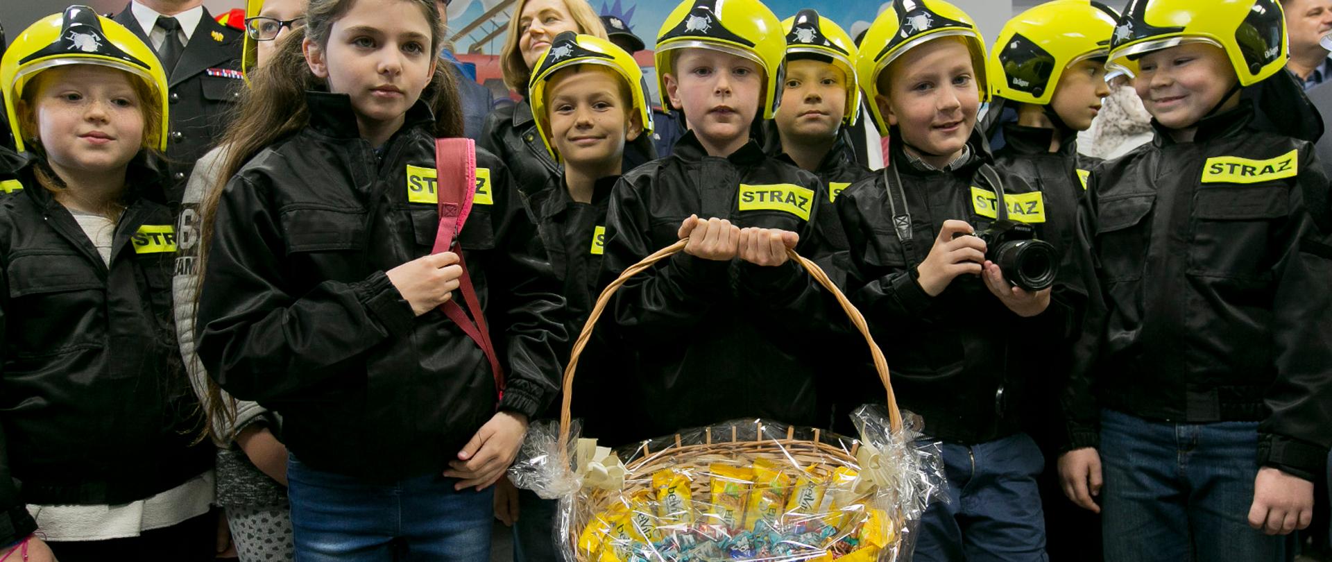 Na zdjęciu dzieci, ubrane w stroje strażaków, podczas zajęć w salce edukacyjnej.