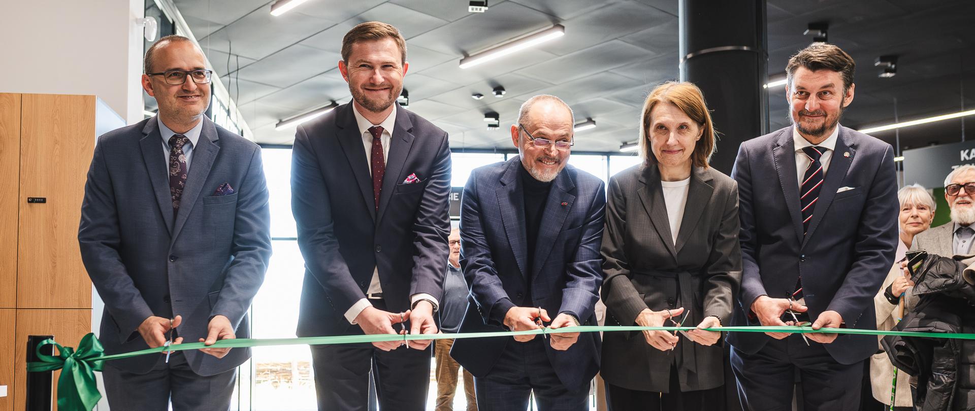 kilka osób przecina wstęgę otwierając symbolicznie centrum informacyjne 
