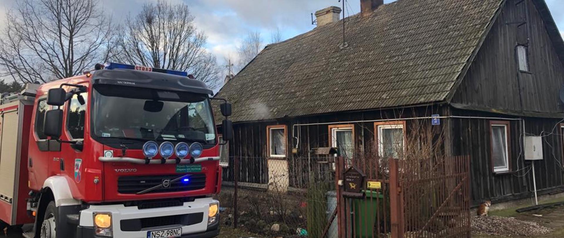 Zdjęcie przedstawia samochód ratowniczo gaśniczy przy domu w miejscowości Zabiele, gdzie maił miejsce pożar 