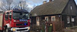 Zdjęcie przedstawia samochód ratowniczo gaśniczy przy domu w miejscowości Zabiele, gdzie maił miejsce pożar 
