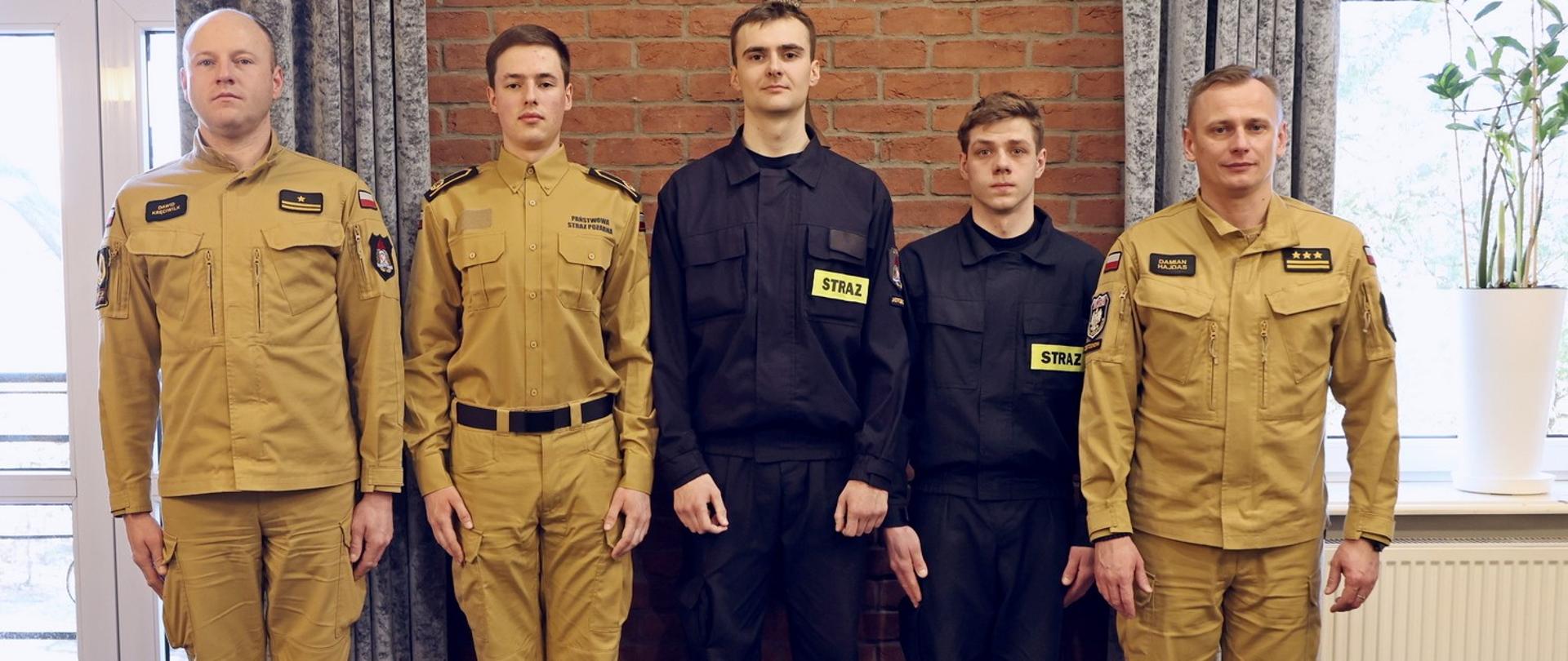 Pamiątkowe zdjęcie trzech wyróżnionych strażaków w towarzystwie p.o. Komendanta Centralnej Szkoły PSP oraz Zastępcy Naczelnika Wydziału Kompanii Szkolnych i Zabezpieczenia Obiektów CS PSP