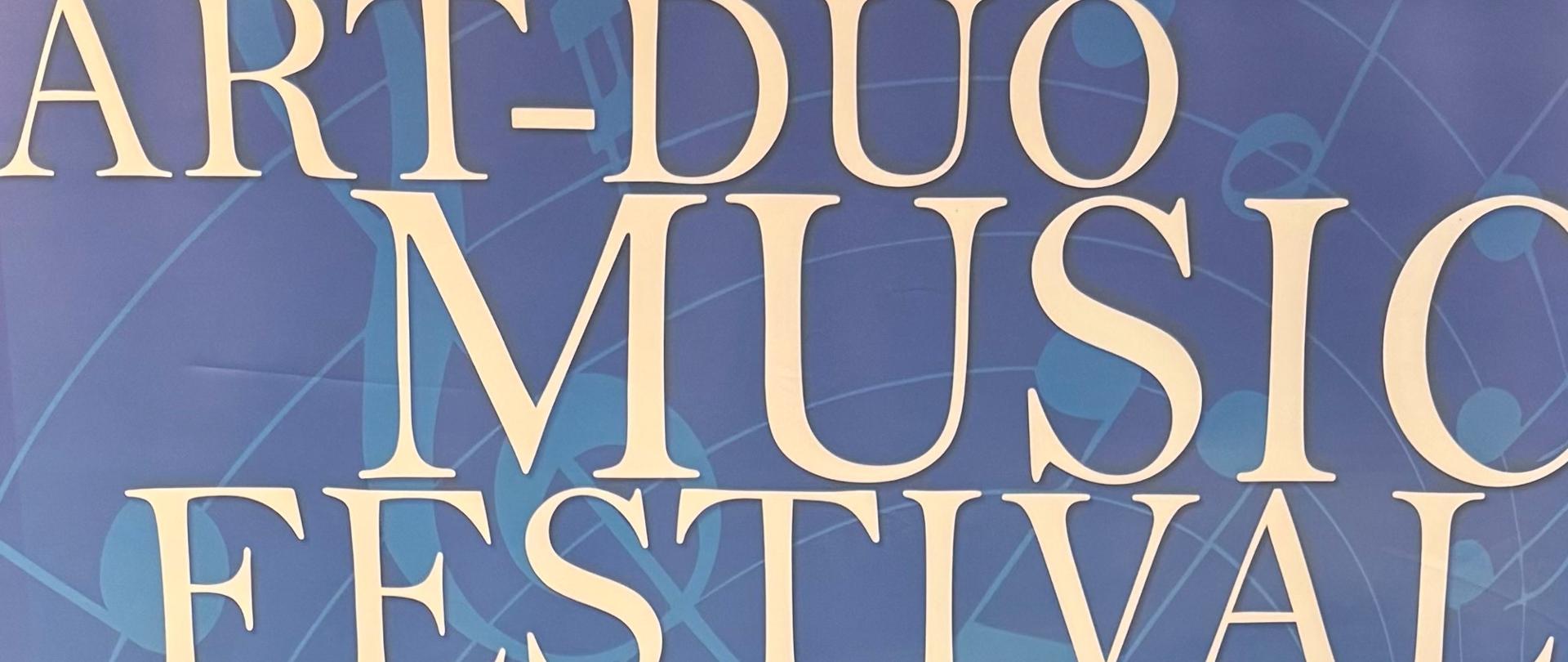 Laura Pietryka Art Duo 2025. Uczennice stojąca z dyplomem i medalem przed banerem reklamowym konkursu