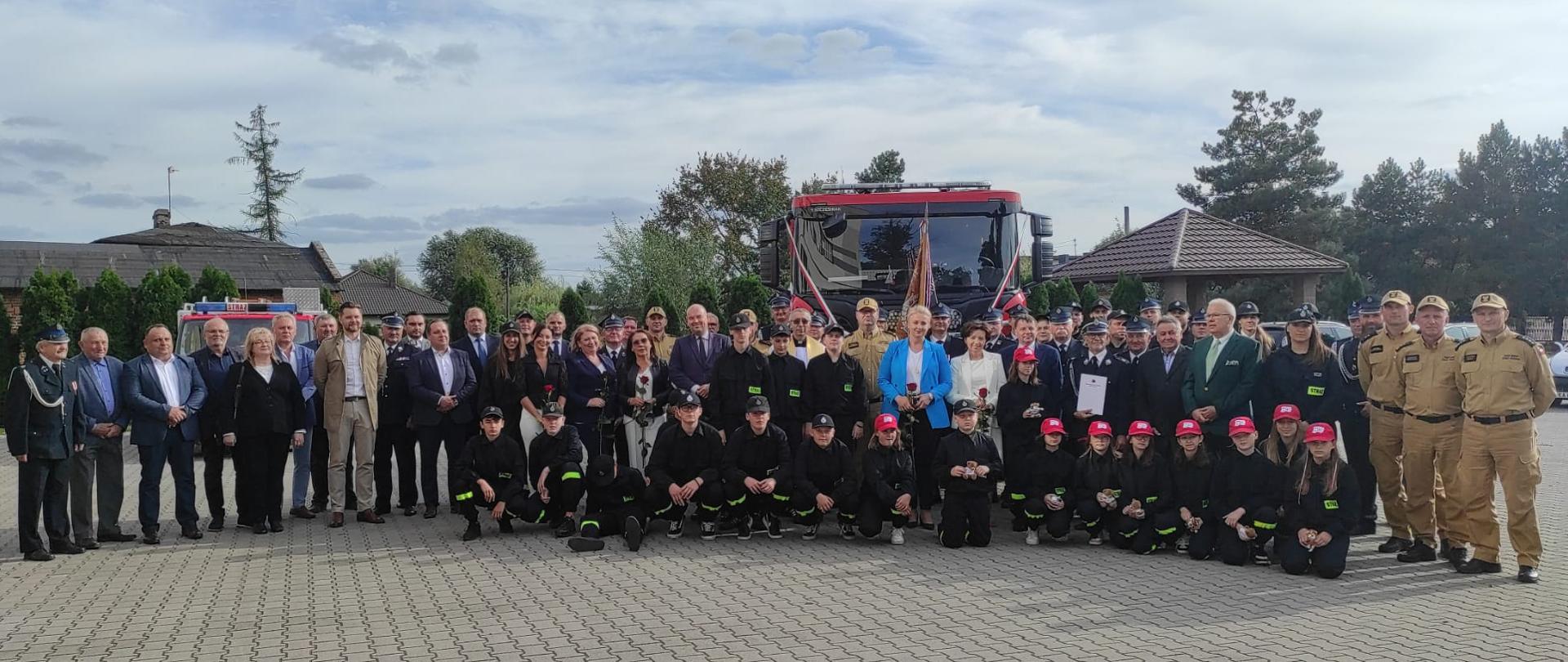 zdjęcie grupowe na placu przed samochodem strażackim
