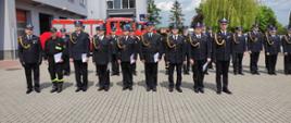 Zdjęcie przedstawia strażaków, którzy stoją na placu przed komendą podczas uroczystości obchodów dnia strażaka
