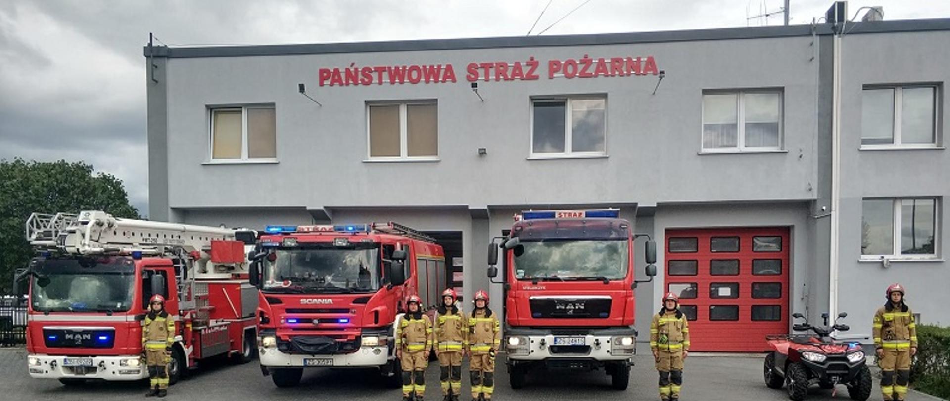 Zdjęcia przedstawia pojazdy strażackie z włączonymi sygnałami świetlnymi i sygnałami przed garażami KP PSP w Białogardzie oddające hołd bohaterom Powstania Warszawskiego w rocznicę wybuchu walk.Strażacy w ubraniach specjalnych stoją przed pojazdami w postawie zasadniczej