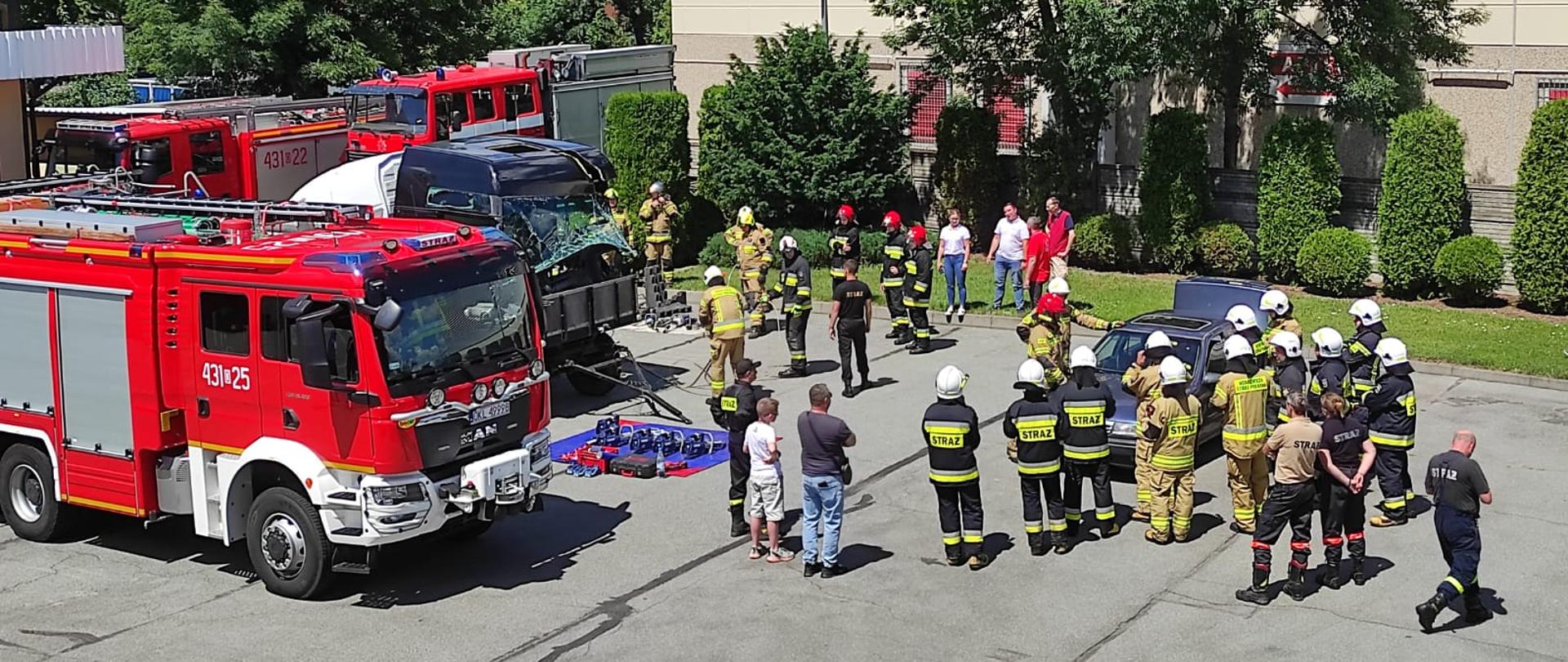 Strażacy OSP i PSP podczas ćwiczeń z ratownictwa technicznego przy stanowiskach ćwiczeń. Stanowiska na placu KP PSP w Kluczborku.