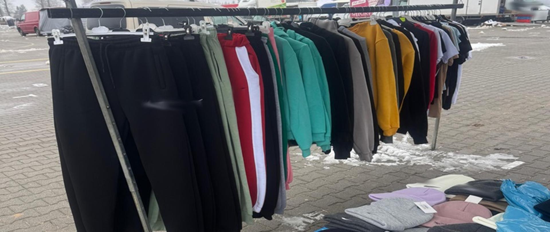 Odzież na wieszakach i na stoisku.