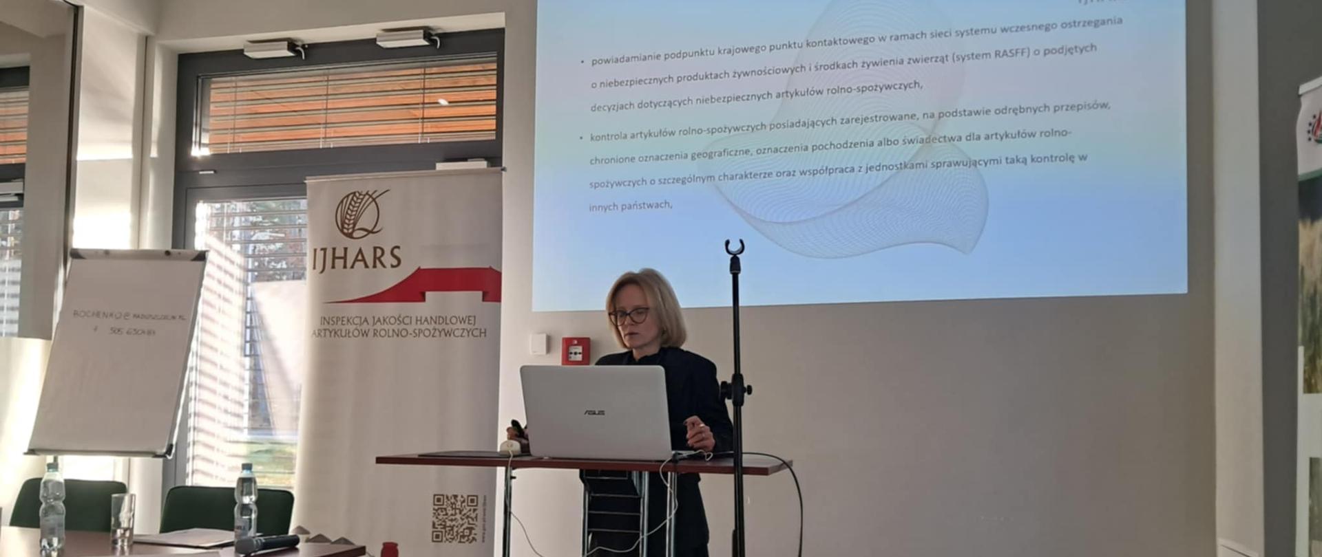Inspektorka IJHARS podczas prezentacji, w tle prezentacja.