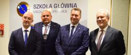 Minister Czarnek i trzech mężczyzn w garniturach stoją pod ścianą z napisem Szkoła Główna Mikołaja Kopernika.