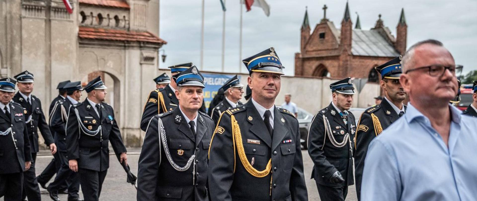 Zdjęcie przedstawia pełniącego obowiązki komendanta powiatowego st. bryg Marka Kalaka oraz dh Mariusza Błaszczyka z OSP Koźmin Wlkp. podczas pielgrzymki służb mundurowych. 