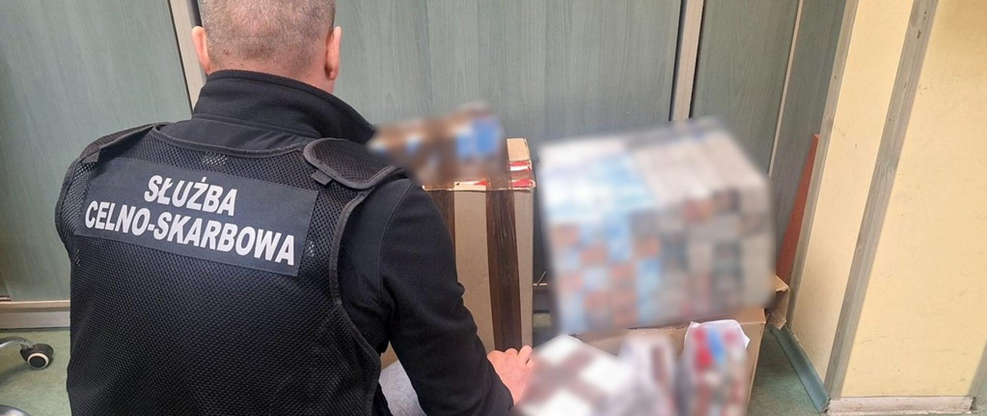 Funkcjonariusz przy zabezpieczonych papierosach