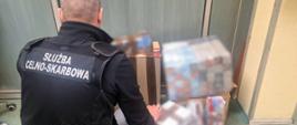 Funkcjonariusz przy zabezpieczonych papierosach