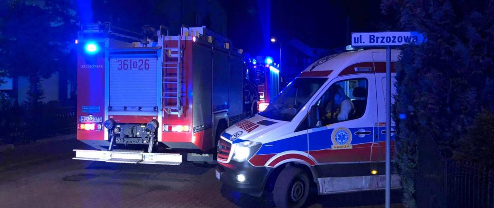 Na zdjęciu karetka wyjeżdzająca z posesji która zabiera osoby poszkodowane w zdarzeniu z udziałem pojawienia się czadu w budynku mieszkalnym 