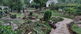 Zdjęcie przedstawia zniszczony ogród po wystąpieniu wody ze strumienia. 
