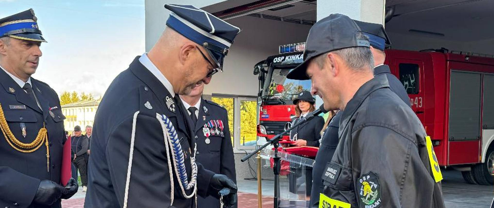 Dwóch strażaków ściska sobie dłoń 