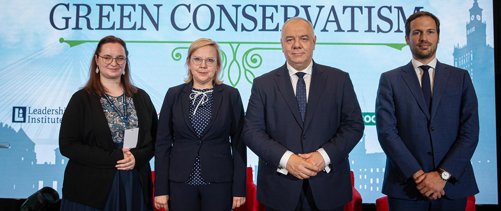 Wicepremier Jacek Sasin, minister Anna Moskwa i organizatorzy stoją na tle ekranu z napisem Green Conservatism.