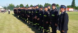 Zdjęcie przedstawia strażaków OSP podczas uroczystego rozpoczęcia zawodów sportowo-pożarniczych.