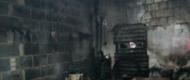 Spalony piec w wyniku pożaru w pomieszczeniu kotłowni. W kotłowni dużo spalonych różnego typu rzeczy.