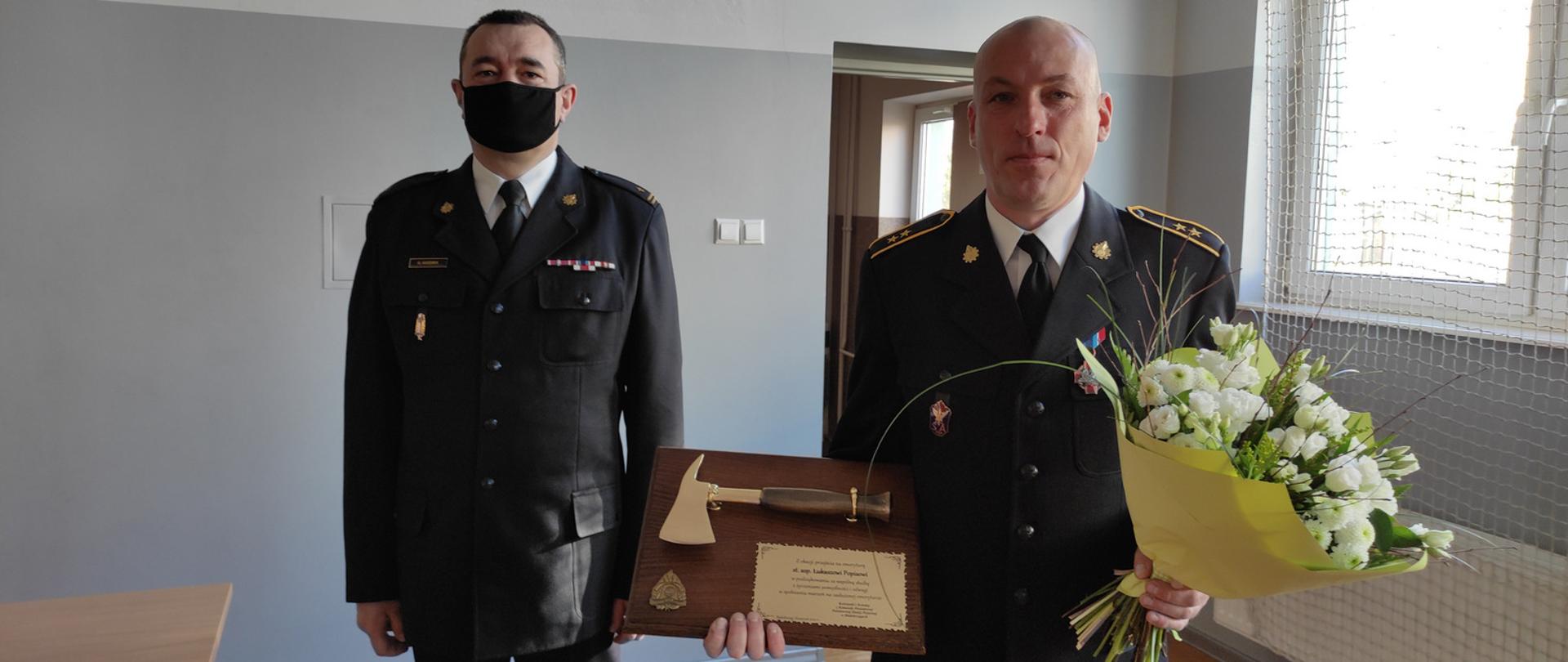 Komendant Powiatowy PSP w Białobrzegach mł. bryg. Grzegorz Gozdek oraz odchodzący na emeryturę Zastępca Dowódcy zmiany st. asp. Łukasz Popis