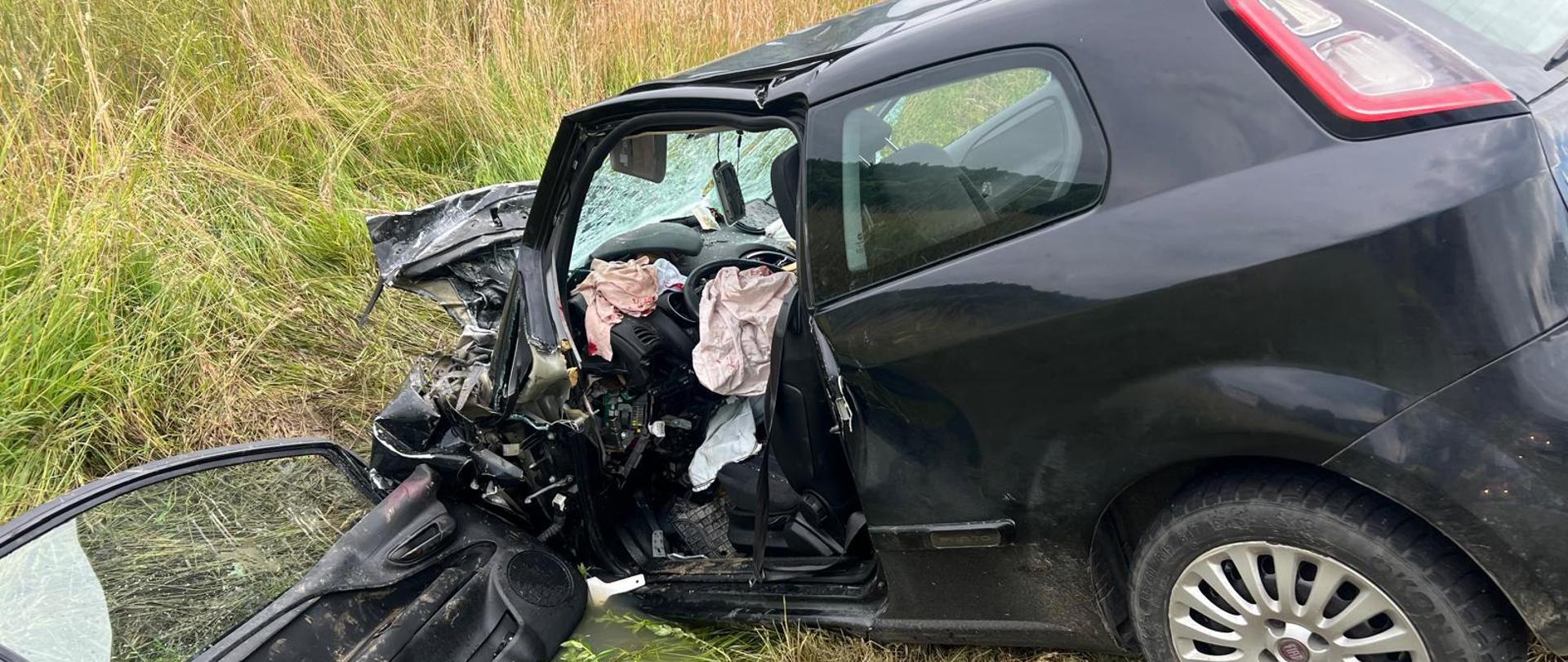 Rozbity samochód osobowy poza drogą