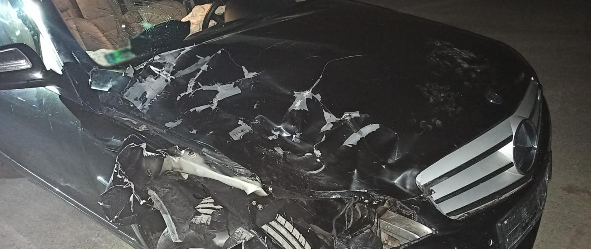 Samochód osobowy koloru czarnego po zderzeniu z jeleniem. Uszkodzony prawy przód.