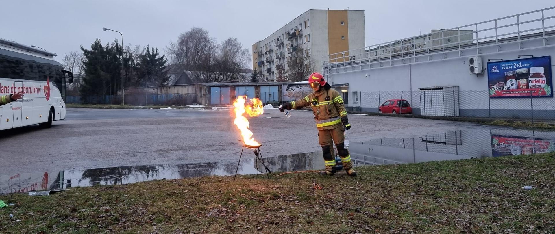 strażak w umundurowaniu specjalnym, gasi płonący tłuszcz 