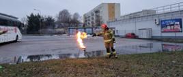 strażak w umundurowaniu specjalnym, gasi płonący tłuszcz 