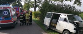 Fotografia przedstawia samochody Państwowej Straży Pożarnej oraz funkcjonariuszy straży pożarnej na miejscu zdarzenia.