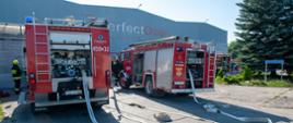 Dwa samochody gaśnicze z rozwiniętymi liniami wężowymi przy zakładzie PrefectDoor