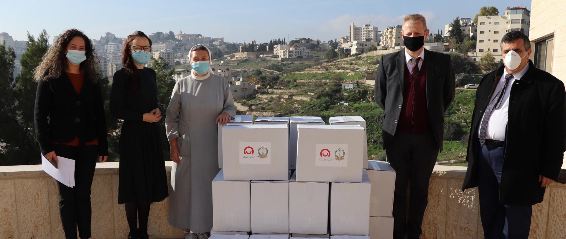 pięć osób z paczkami do przekazania