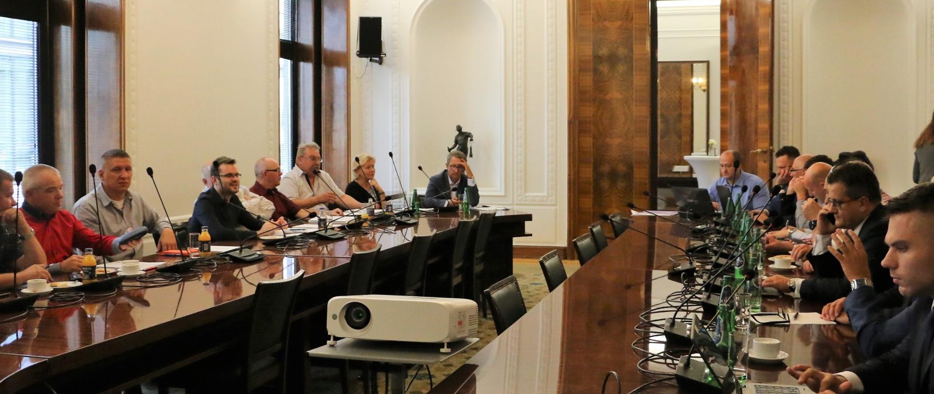 uczestnicy siedzący za stołem