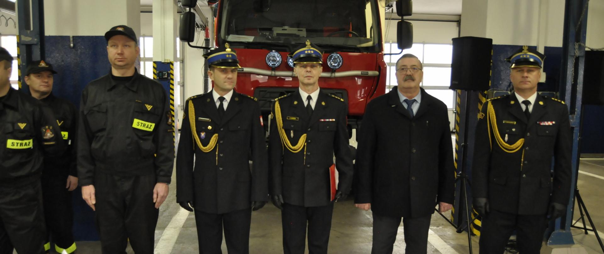 Zdjęcie przedstawia st.bryg. Roberta Wiśniewskiego – Zastępcę Kujawsko-Pomorskiego Komendanta Wojewódzkiego Państwowej Straży Pożarnej, Stanisława Kosakowskiego – Wicestarostę Brodnickiego, oraz przedstawicieli Komendy Powiatowej PSP w Brodnicy odbierających nowy samochód. 
