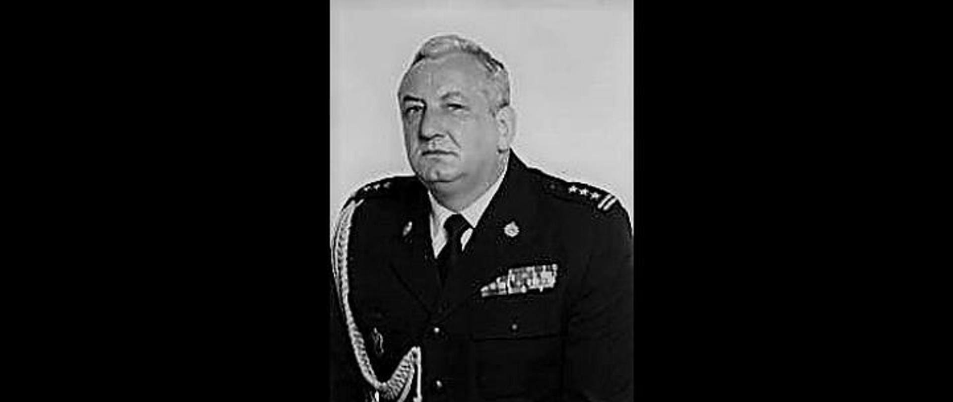 Zdjęcie przedstawia postać zmarłego st. bryg. w st. spocz. Bogusława Śliwińskiego w czarno białych kolorach, ubranego w mundur wyjściowy. 