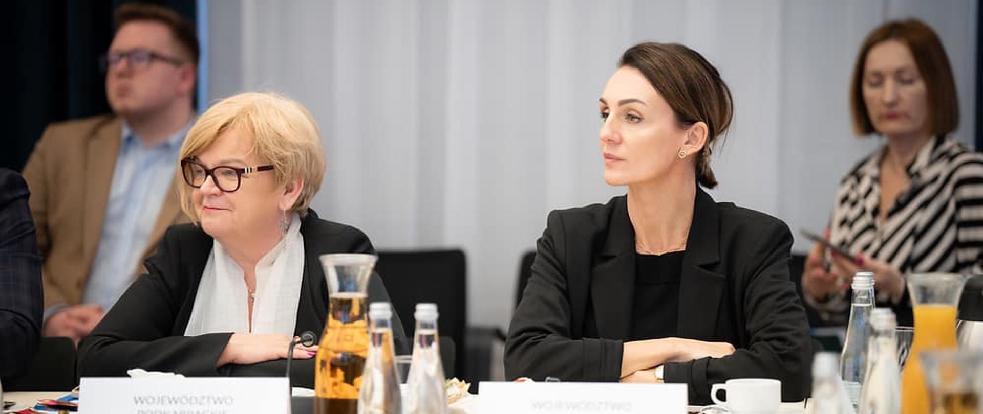 stół, siedzą osoby i słuchają, narada w gmachu ministerstwa 