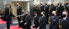 Komendant Główny PSP nadbrygadier Andrzej Bartkowiak i Zastępca Komendanta Głównego nadbrygadier Adam Konieczny w trakcie pasowania na oficera i wręczania aktu nadania pierwszego stopienia oficerskiego funkcjonariuszom PSP. W tle awansowani funkcjonariusze. 