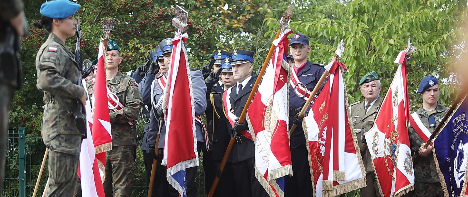 Zdjęcie przedstawia poczty sztandarowe służb wystawione w czasie uroczystości.