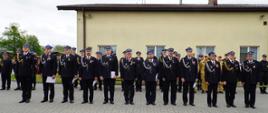 Kilku druhów w mundurach galowych stoi w pierwszym rzędzie podczas ceremonii wręczenia odznaczeń i wyróżnień. Część z nich trzyma dyplomy oraz odznaczenia.