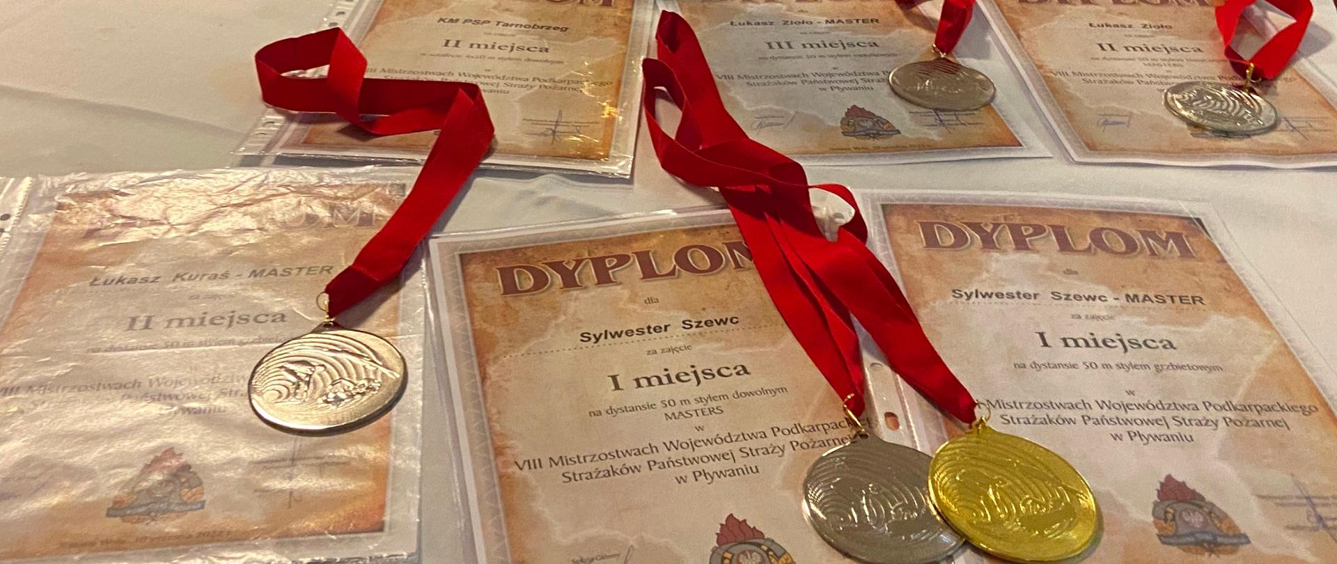 Medale oraz dyplomy za zajęcie czołowych miejsc w mistrzostwach pływackich.