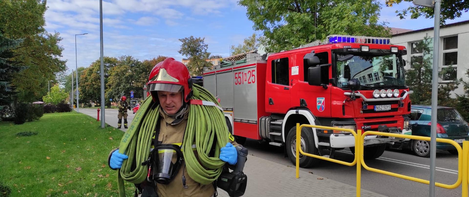 Zdjęcie przedstawia zastępy pożarnicze podczas ćwiczeń dowódcy Jednostki Ratowniczo-Gaśniczej na Zespole Szkół nr 3 w Szczytnie