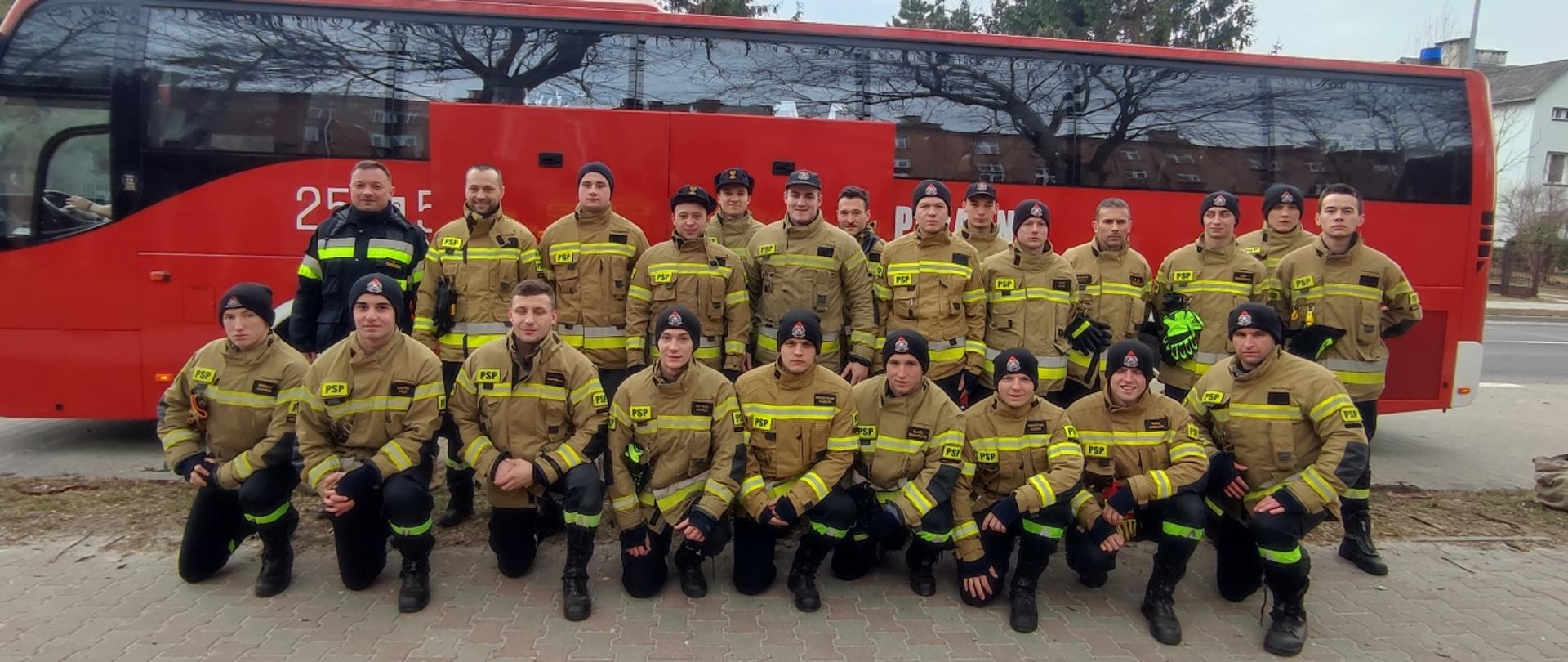 Zdjęcie grupowe kadetów Centralnej Szkoły PSP w towarzystwie dwóch dowódców na tle autokaru PSP