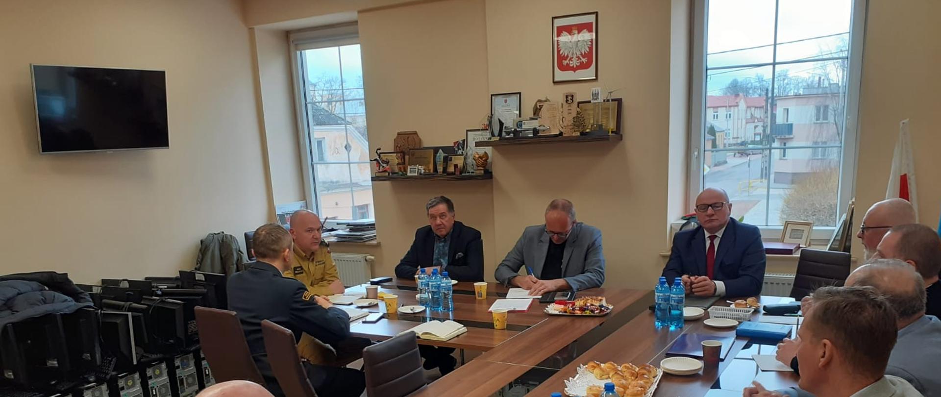 Posiedzenie Zarządu Powiatowego ZOSP RP powiatu grajewskiego. Członkowie Zarządu oraz zaproszeni goście siedzą przy stole konferencyjnym.