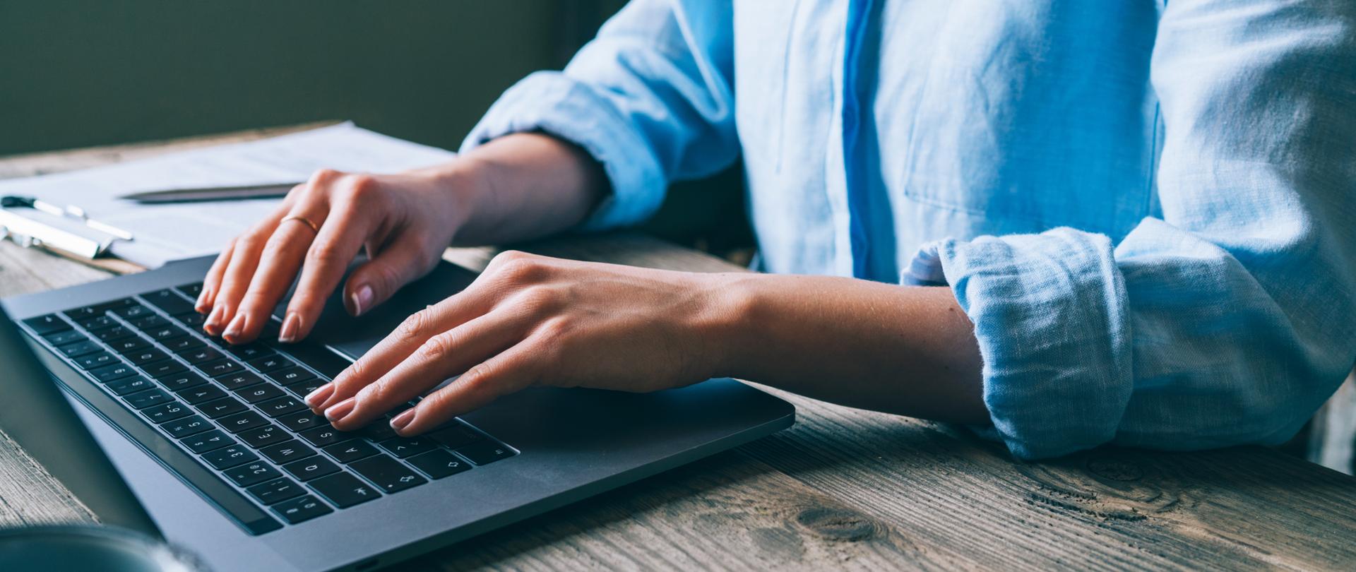Kobieta pisząca na klawiaturze laptopa