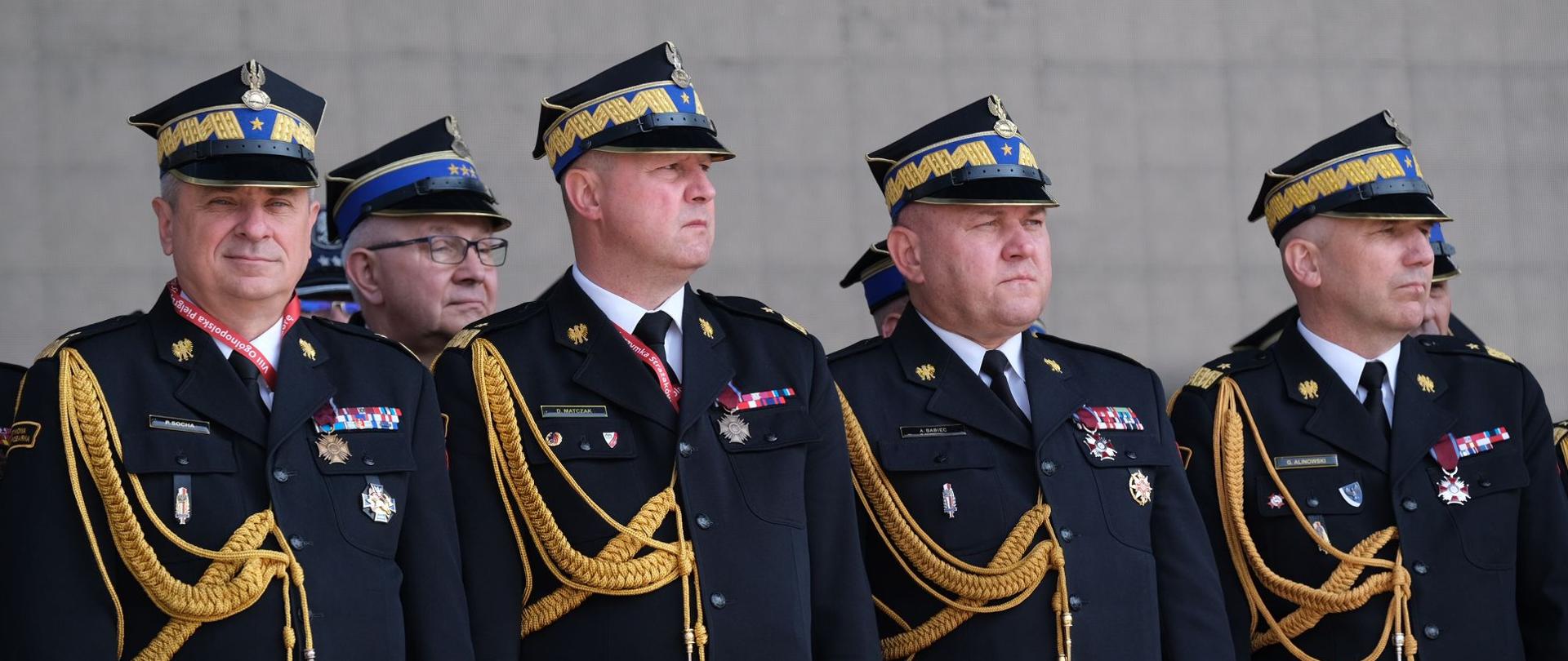czterech generałów straży pożarnej stoi na bacznosć 