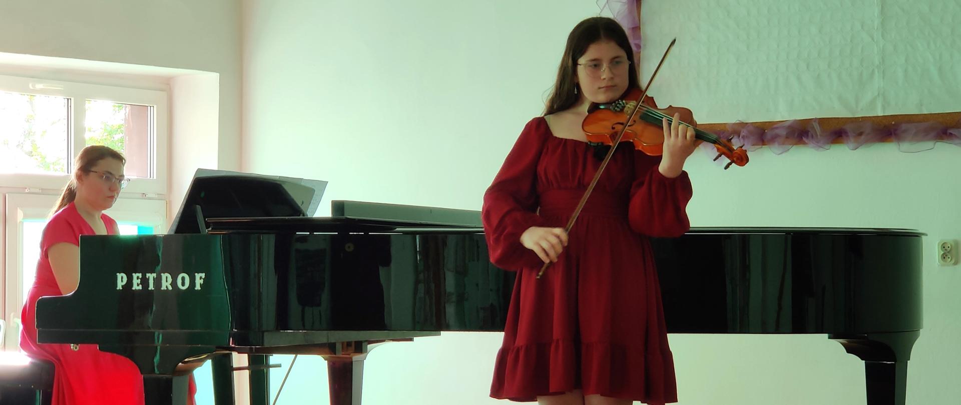 Zdjęcie przedstawiające uczestnika koncertu utworów kompozytorów polskich na skrzypcach przy akompaniamencie fortepianowym pani Lilii Tarasenko, w trakcie koncertu w auli szkoły w dniu 18.05.2023 r.