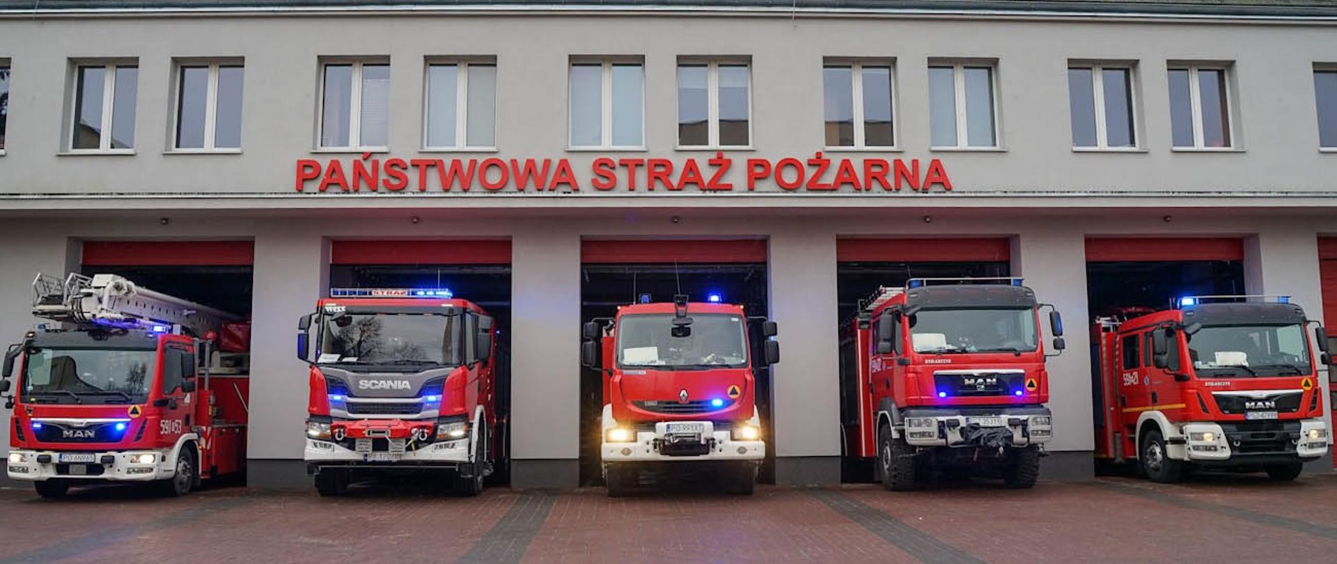 Samochody strażackie na tle Komendy Powiatowej PSP