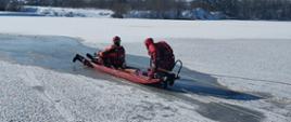 Strażacy za pomocą sań lodowych poruszają się po zamarzniętym akwenie