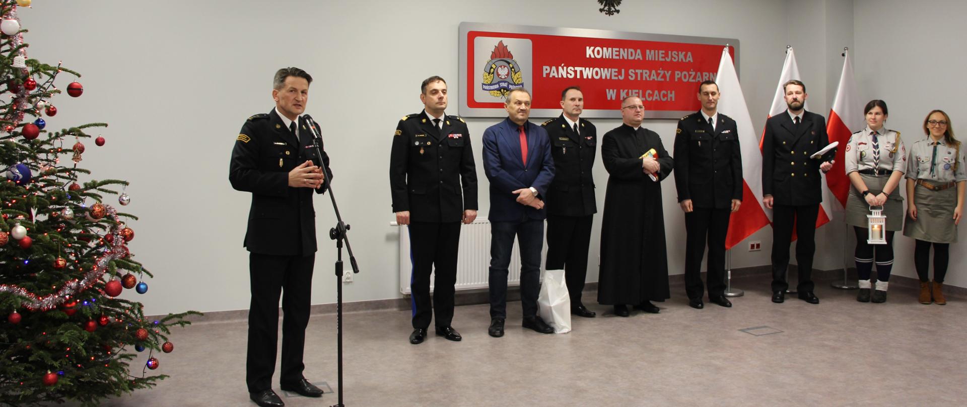 Zdjęcie przedstawia gości zaproszonych na strażacką wigilię. Wśród nich Komendant Miejski PSP w Kielcach bryg. Mariusz Góra i jego zastępca bryg. Michał Jankowski.