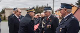 Zastępca komendanta głównego PSP w trakcie wręczania wyróżnień druhom OSP ustawionym w szeregu. 
